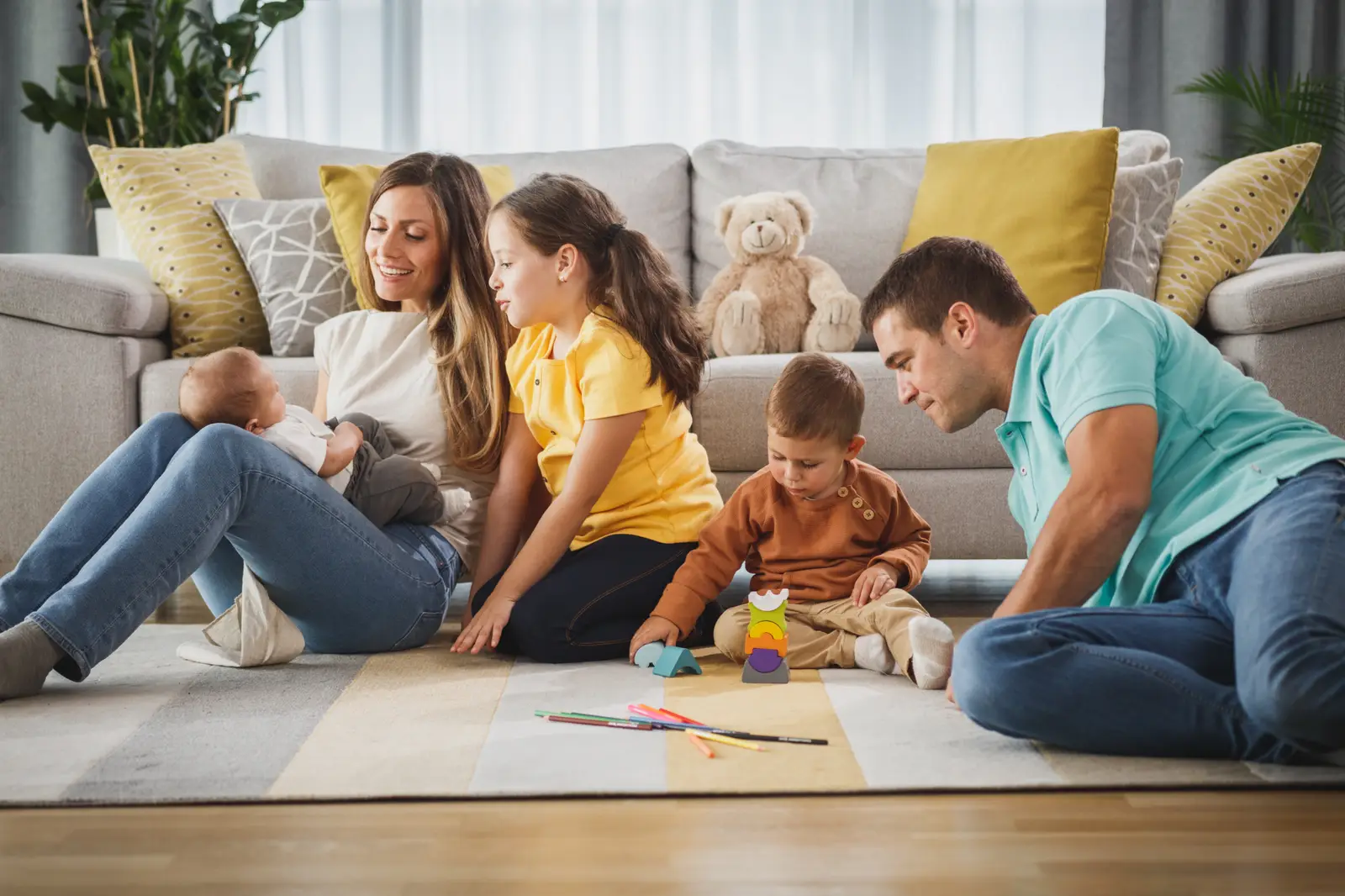 Família na sala com celular e tablet controlando a internet para casa inteligente