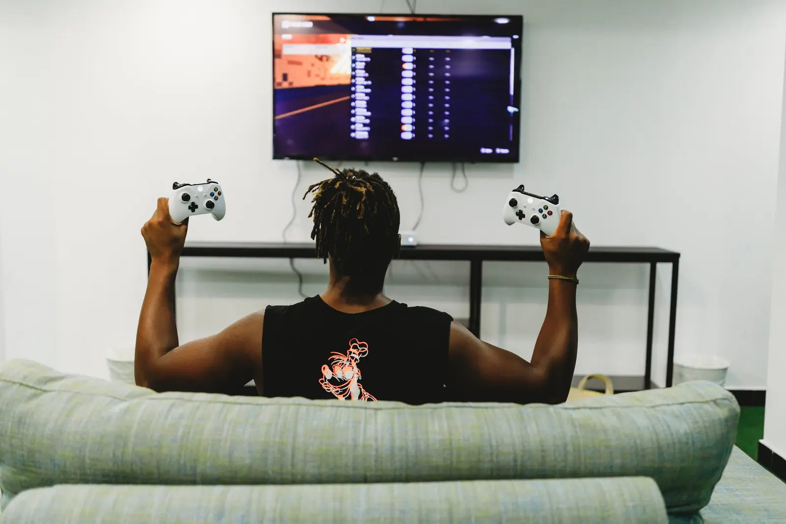 Jovem jogando videogame online na televisão da sala