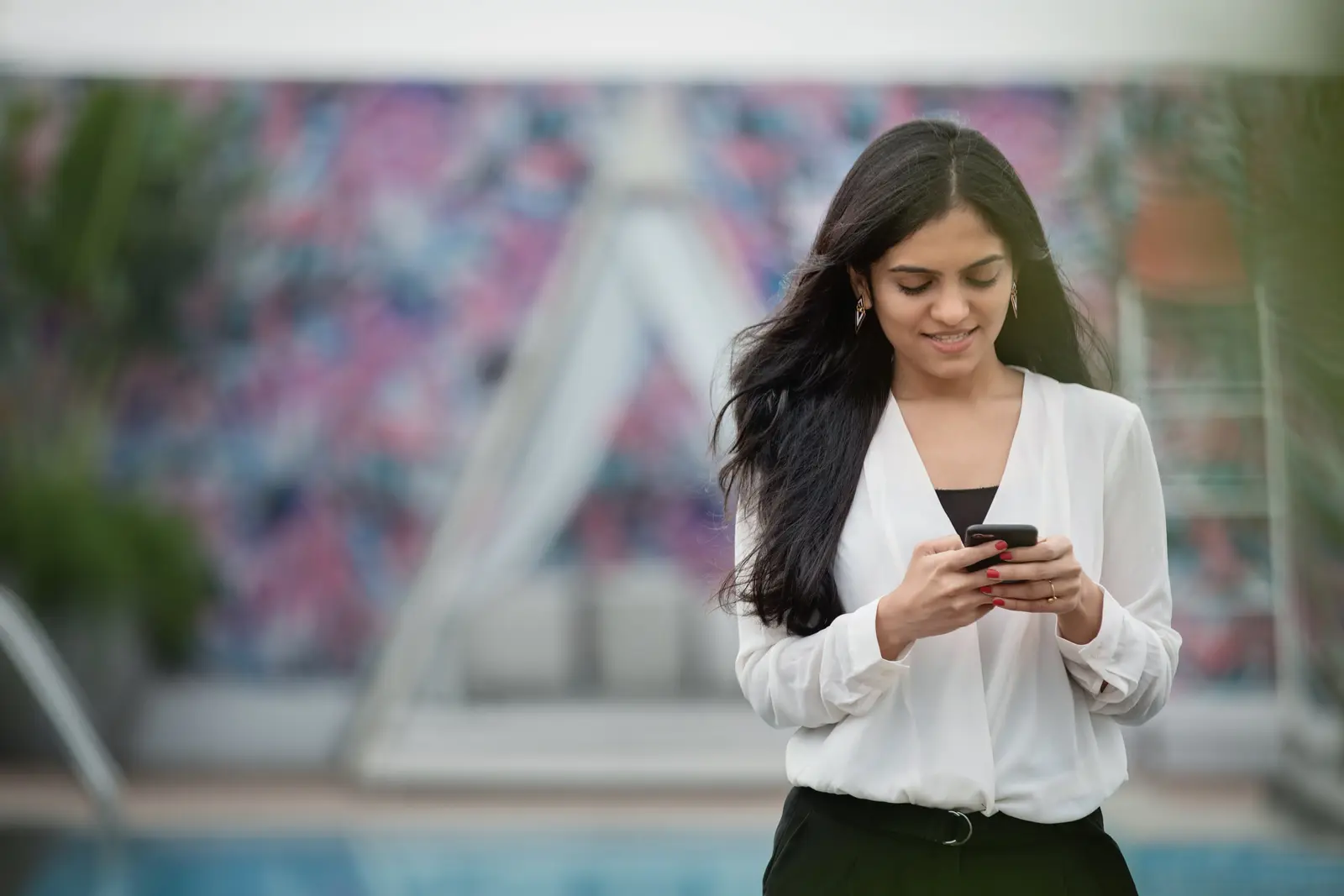 Mulher sorrindo enquanto usa o celular