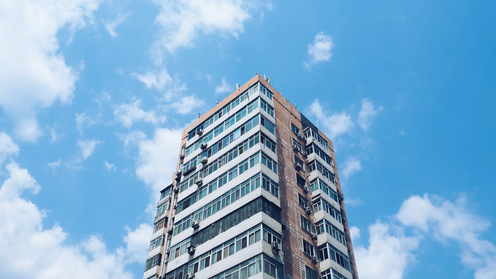 Torre de apartamentos contra o céu azul, condomínio que contratou internet para condomínio em fibra