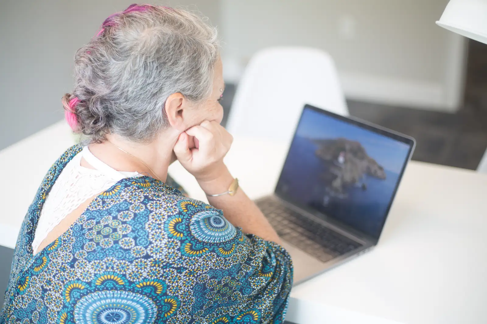 Senhora consultando o contrato no notebook antes de cancelar internet sem multa